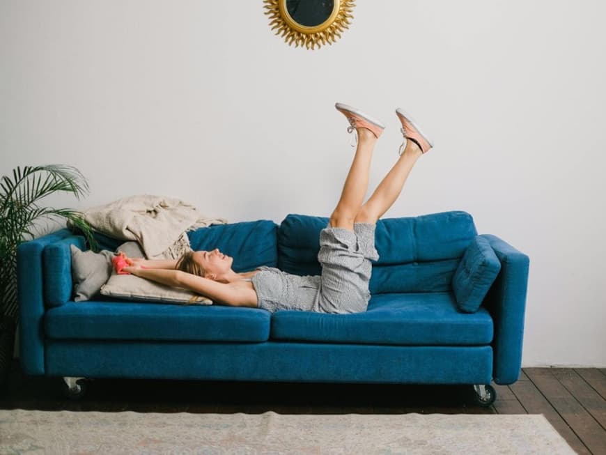 Frau liegt auf einer Couch