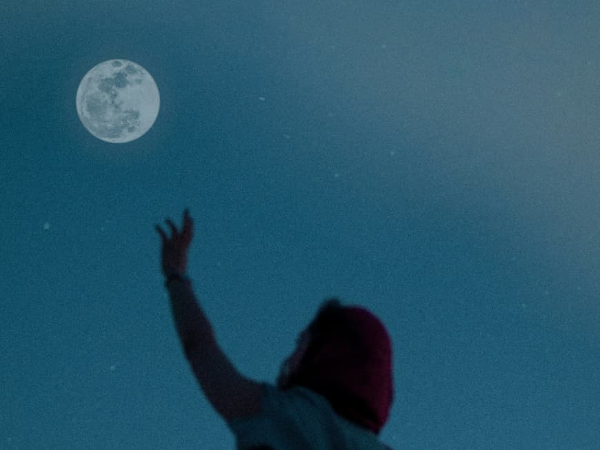 Das ist dein Glückstag im Mai – nach Sternzeichen. Frau streckt Arm zum Mond