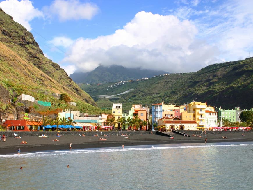 Bunte Häuser an der Küste von La Palma an einem Strand mit dunklem Sand.
