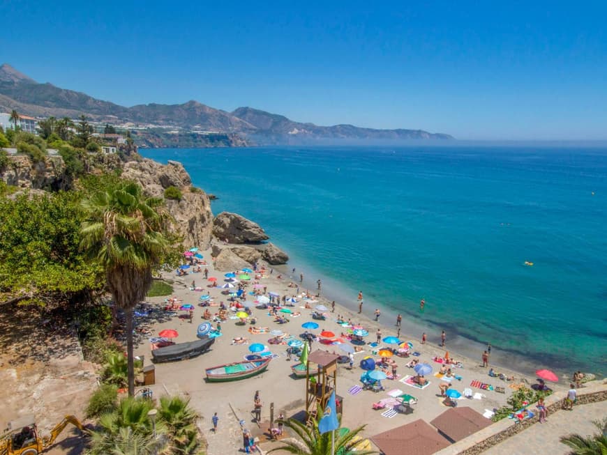 Malaga ist ein beliebtes Reiseziel. Ein Strand in Malaga mit vielen Menschen und Sonnenschirmen.