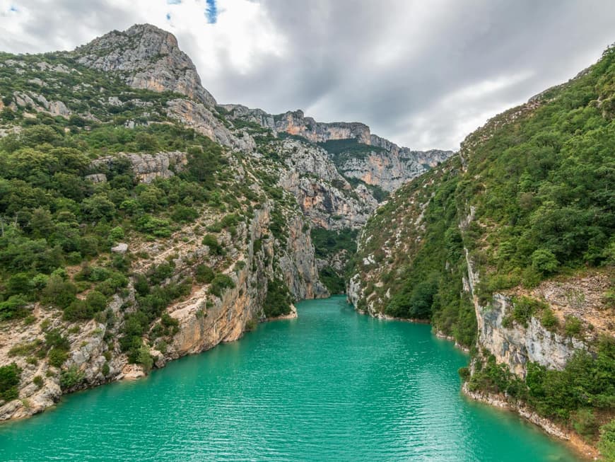 Gebirge mit Pflanzen und türkisblauem Wasser dazwischen.