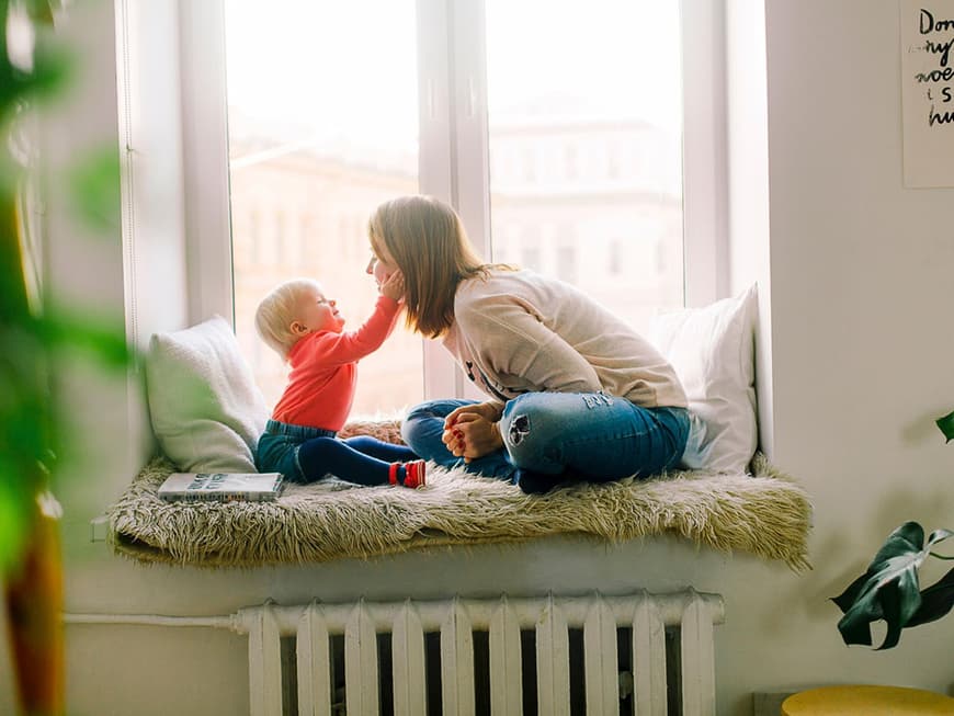 Baby hält das Gesicht einer jungen Frau