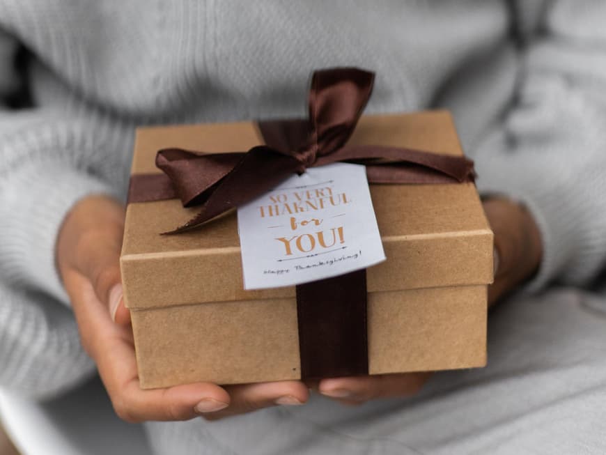 Eine Frau hält ein Geschenk in den Händen