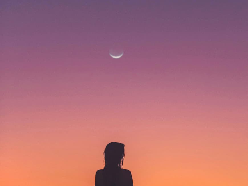 Frau schaut in den Abendhimmel