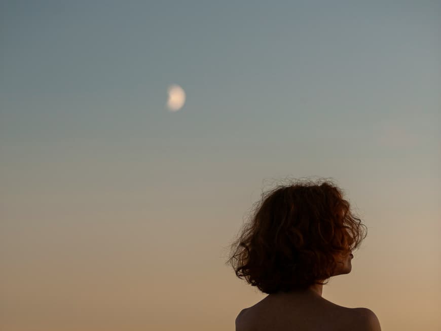 Frau schaut in Abendhimmel