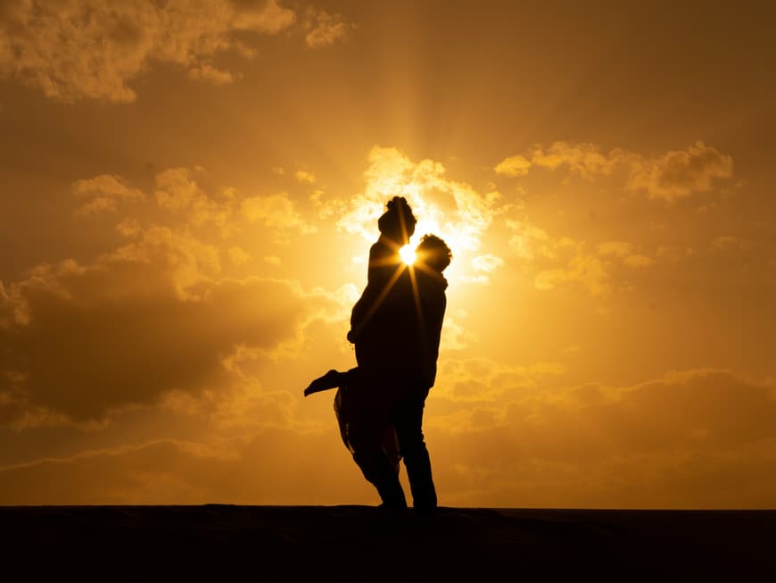 Welche 5 Sternzeichen im August das absolute Liebesglück erwartet, liest du hier. Pärchen vor Sonnenuntergang