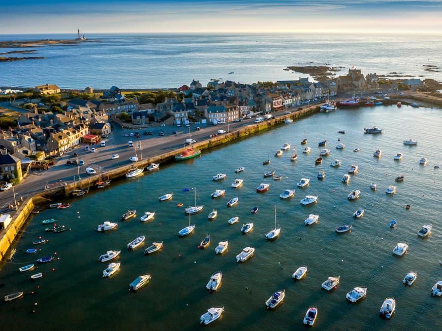 Barfleur ist perfekt für alle, die in Ruhe etwas entdecken möchten. Ein Blick auf den Hafen mit einer Landzunge mit Häusern und vielen Booten auf dem Wasser.