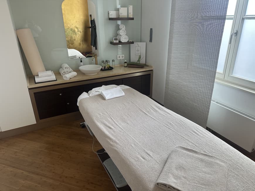 Auf einer bequemen Massageliege wurde die brasilianische Lymphdrainage angewendet. Eine Massageliege mit Handtüchern und einigen Produkten im Hintergrund.