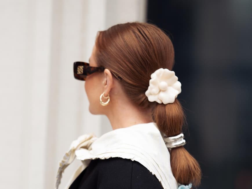Blumenspangen liegen total im Trend, denn sie wirken herrlich fröhlich und feminin. Frau trägt Blumenspange