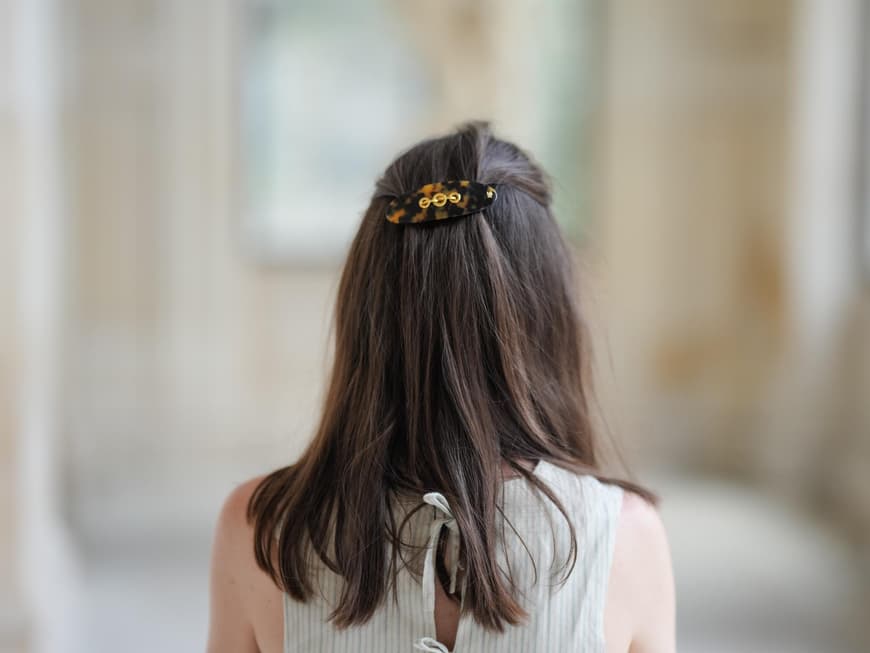 Haare aus dem Gesicht? Im Sommer ein Muss! Mit dieser einfachen Frisur ist das Problem gelöst. Frau mit Spange am Hinterkopf