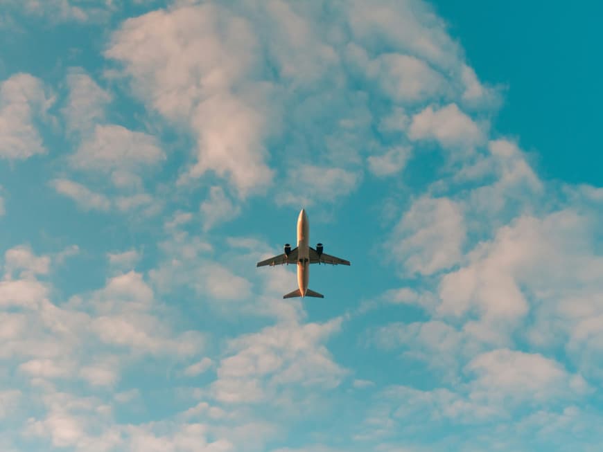 Flugzeug unter blauem Himmel mit Wolken