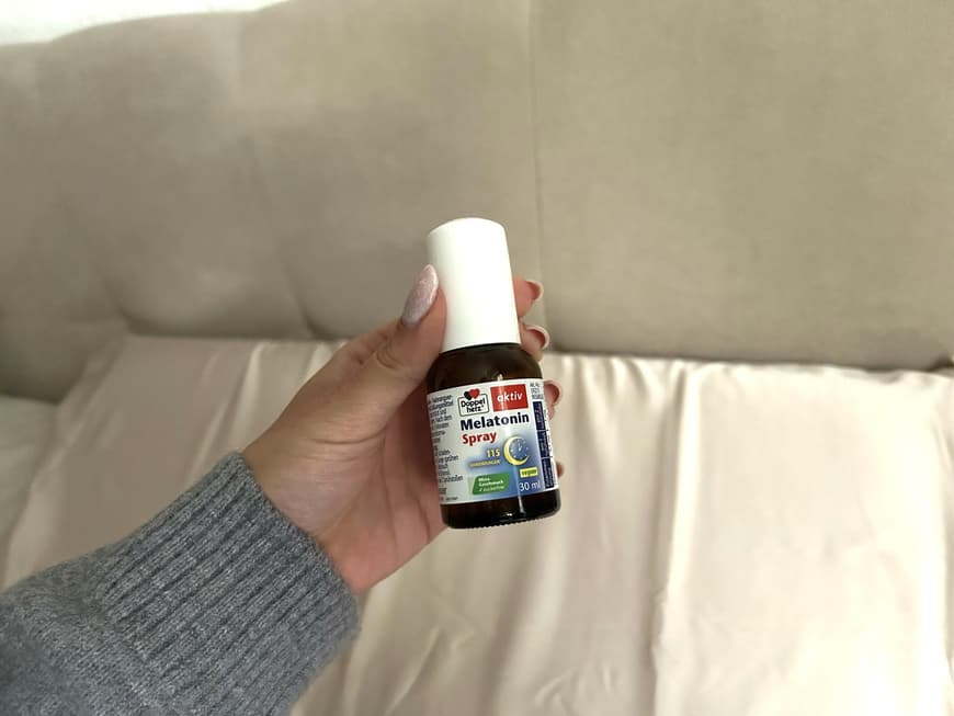 Melatonin Spray von Doppelherz wird in den Händen gehalten.