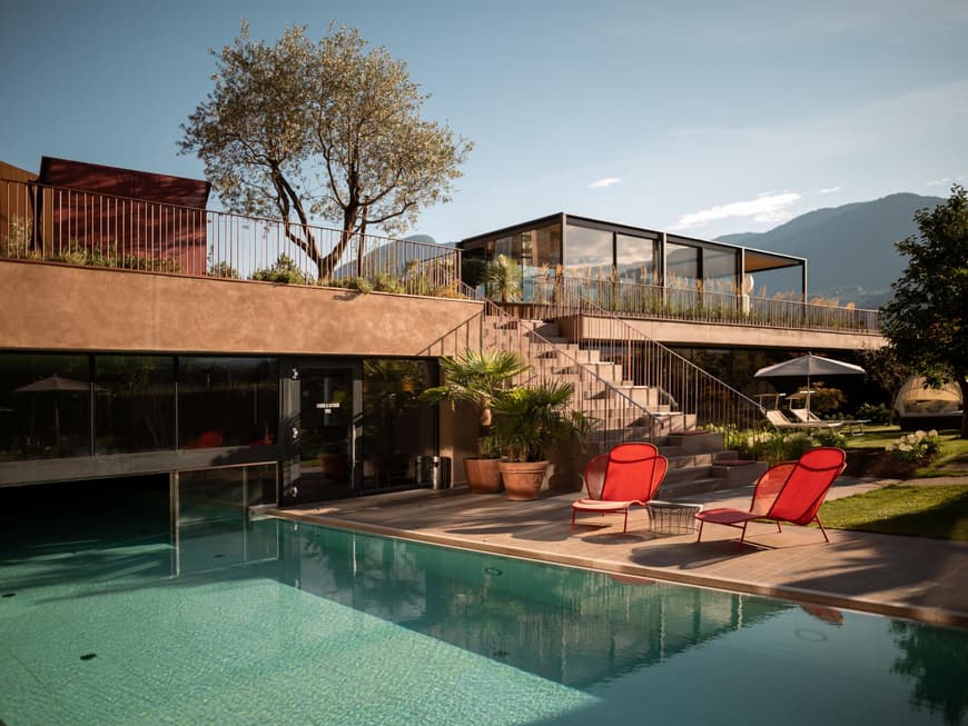 Auf der Terrasse lässt es sich in der Sonne super aushalten. Vinum Hotel Muchele Terrasse mit Außenpool, Stühlen und Pflanzen