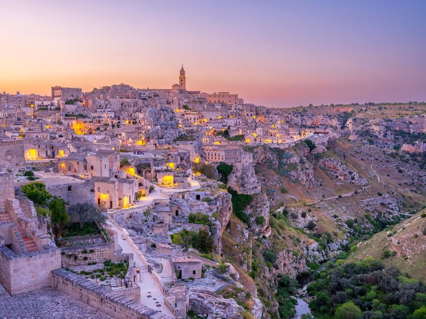 Zum Sonnenuntergang wird Matera in einen lilafarbenen Film gehüllt. Matera mit vielen kleinen Häusern bei Sonnenuntergang.