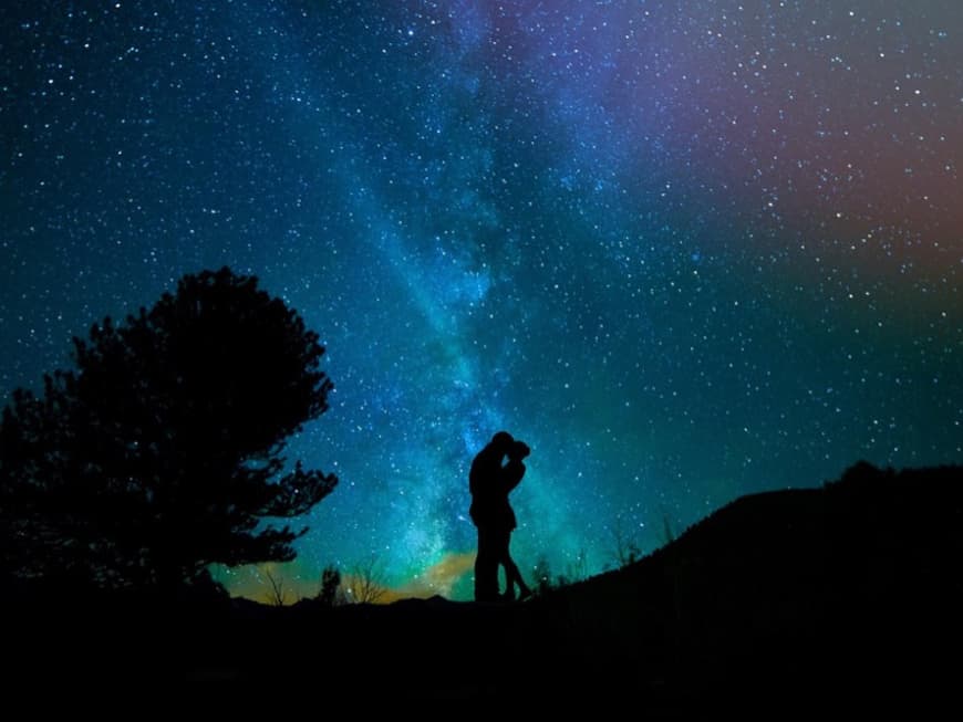 Ein Paar steht unter einem Sternenhimmel