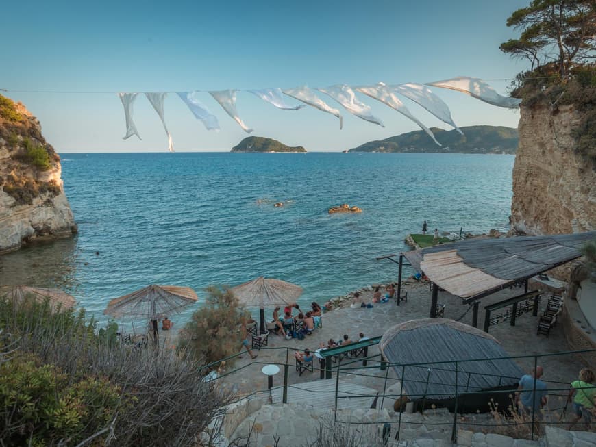 In Laganas erwarten dich tolle Beach Clubs zum Entspannen. Ein Beach Club an der Küste von Cameo Island mit ein paar Menschen.