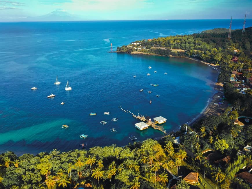 Der Senggigi Beach in Lombok ist ein echtes Paradies. Eine Bucht mit blauem Wasser, Booten darauf und Palmen an der Küste entlang.