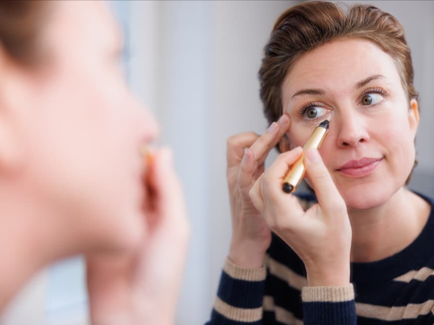 Frau trägt Concealer auf Frau trägt Concealer auf
