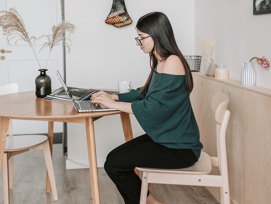 Eine junge Frau sitzt am Laptop