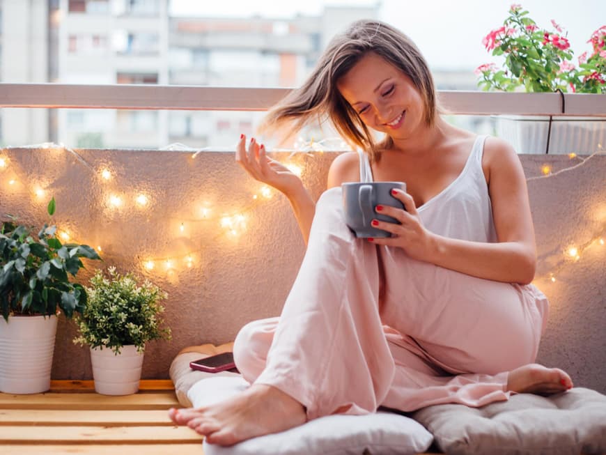 Eine Frau sitzt auf dem Balkon