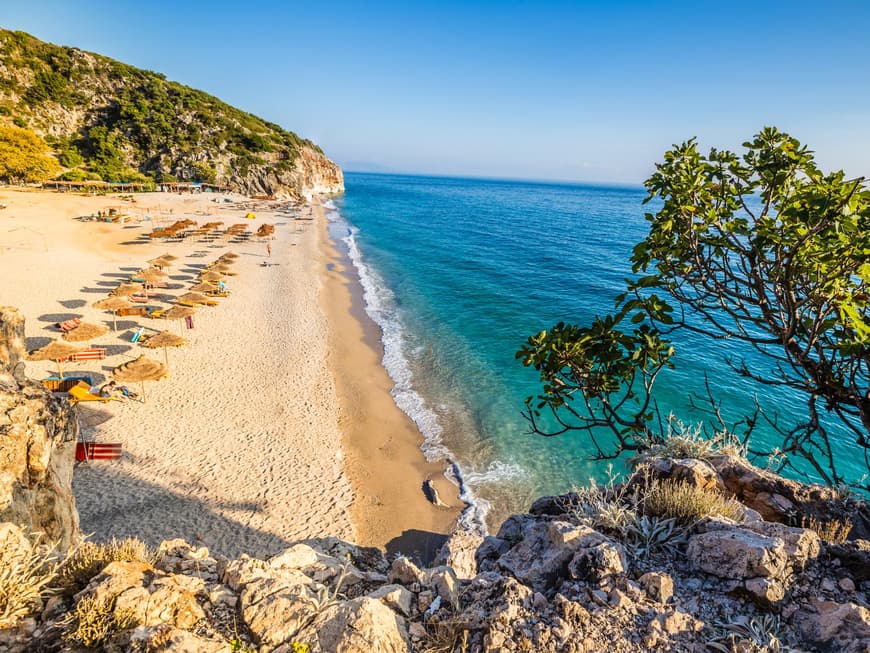 Ein Strand in Himare in Albanien mit türkisblauem Wasser und rauer Natur.