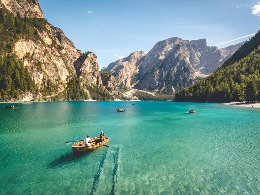 In der Natur lässt sich am besten der Kopf ausschalten. Ein großer See mit Gebirge im Hintergrund und ein paar Booten auf dem Wasser.