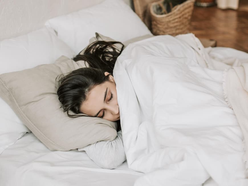 Eine Frau schläft in ihrem Bett