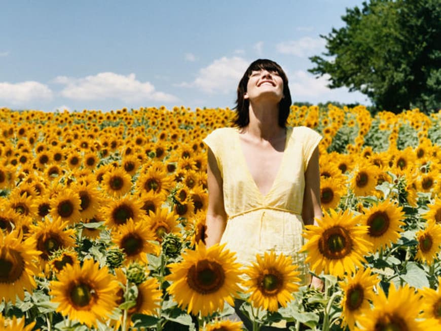 Junge Frau in Sonnenblumenfeld