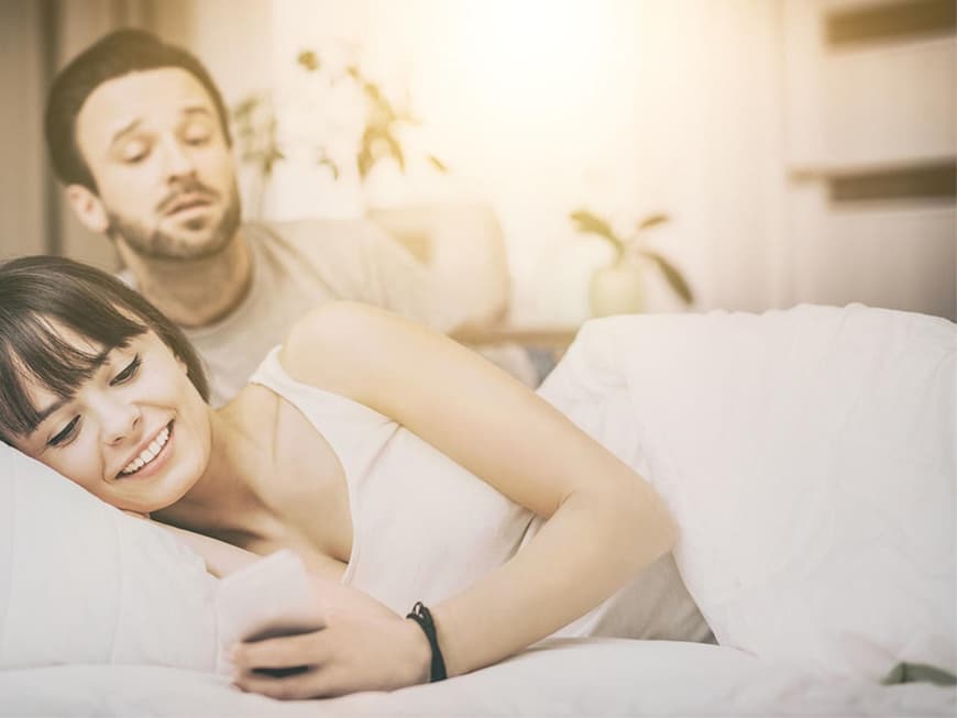 Eine Frau schaut auf ihr Handy - geht sie online fremd? Eine Frau schaut auf ihr Handy - geht sie online fremd?